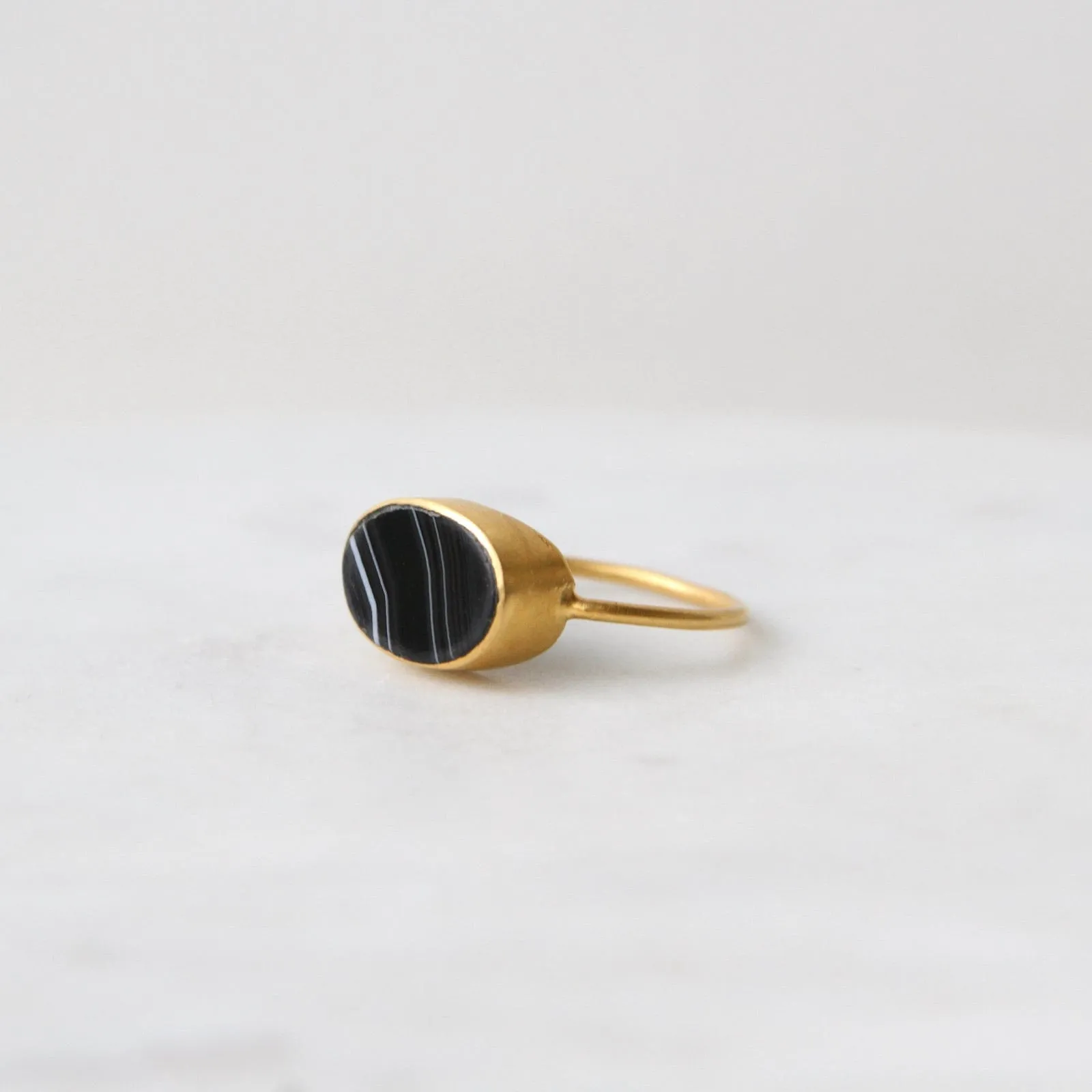 Oval Flat Cut Banded Black Onyx in Gold Plated Bra