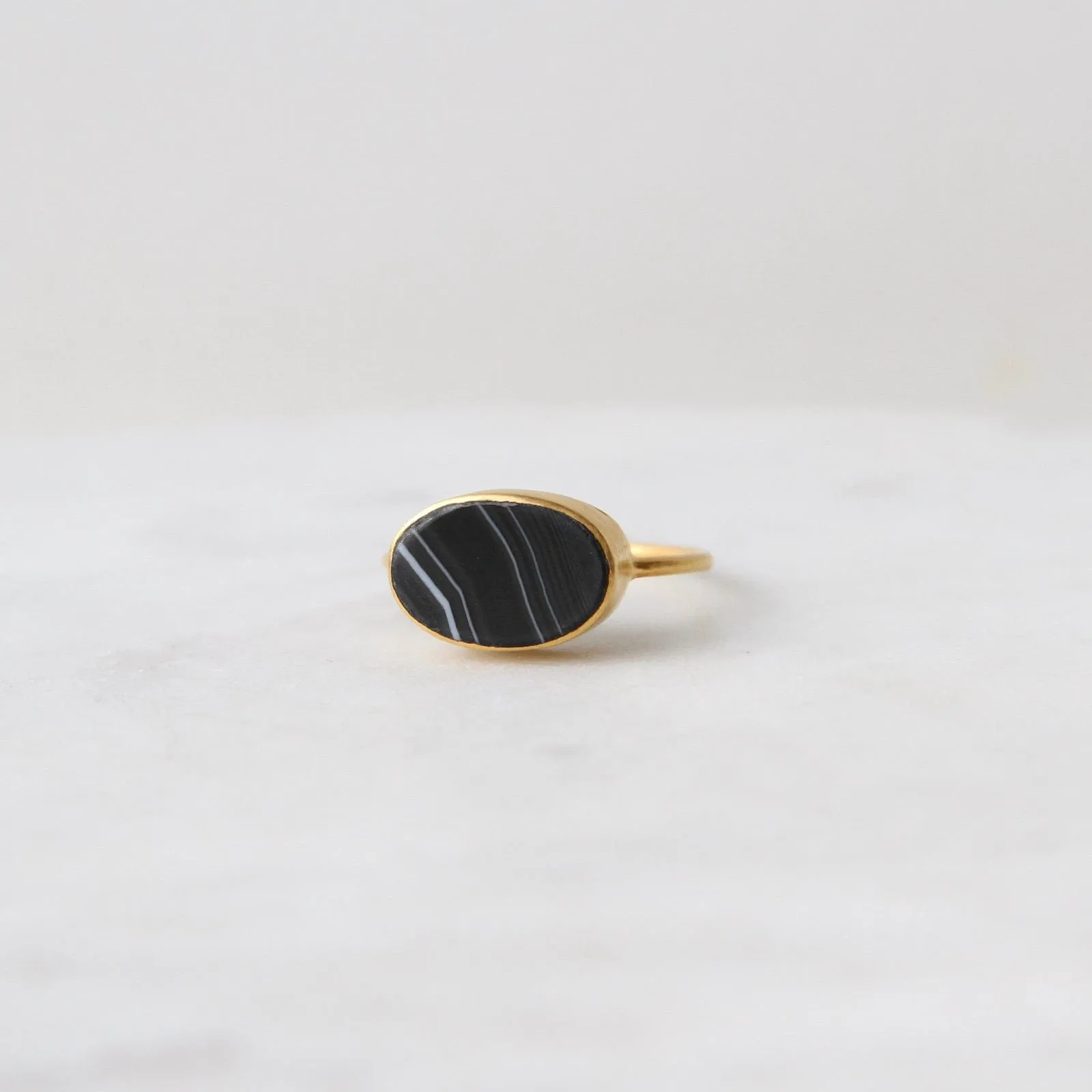 Oval Flat Cut Banded Black Onyx in Gold Plated Bra
